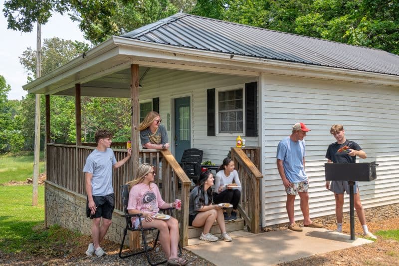 models cooking hot dogs on a bbq grill on a porch