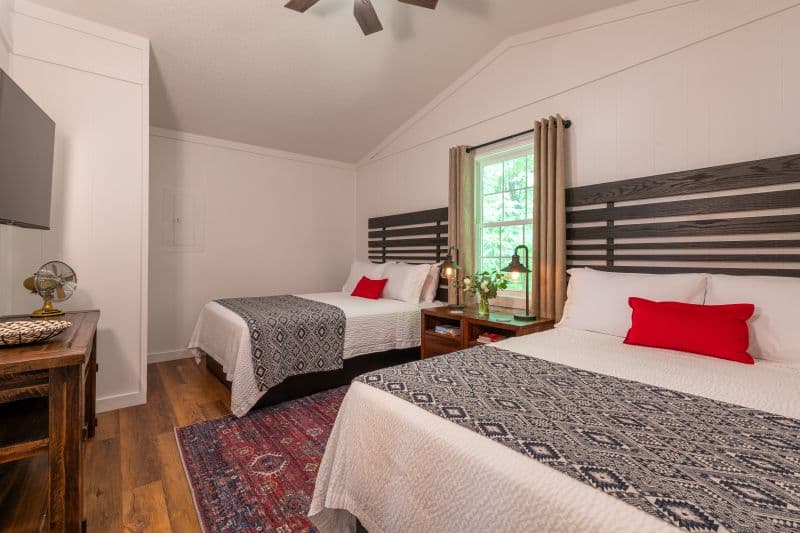 bedroom with two queen beds, a tv, and a table underneath