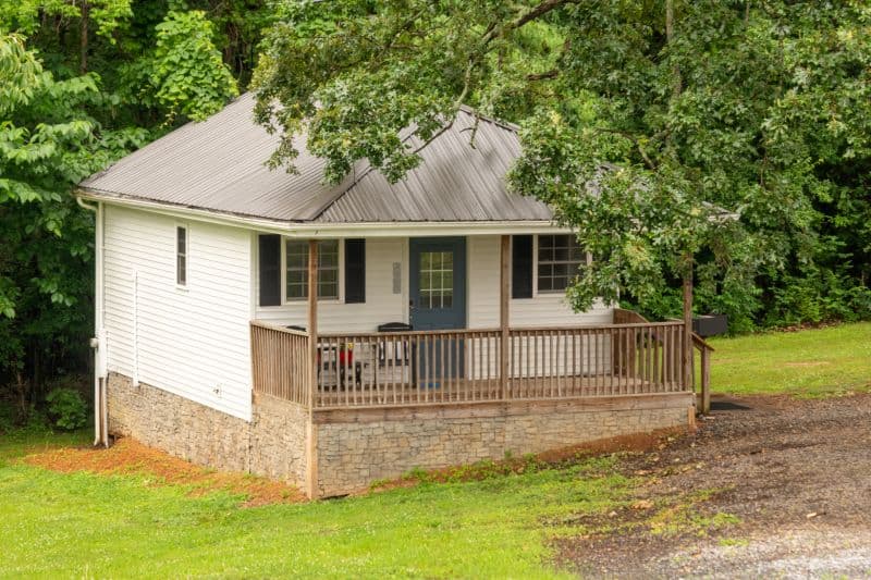 white cabin with stairs to porch